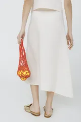 Conjunto de top sin mangas y falda midi color fucsia, con botones dorados. La falda presenta una abertura lateral.