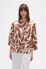 Camisa holgada con estampado de hojas en tonos marrones y beige, cuello mao, cierre frontal con botones y un bolsillo en el pecho.