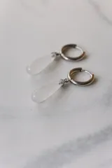 Aros colgantes de acero quirúrgico hipoalergénico con dije de piedra natural en forma de gota color azul oscuro.