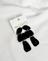 Aros colgantes de acrílico negro con formas geométricas irregulares.