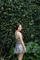 Vestido corto de lentejuelas color verde oliva, con escote en V, breteles finos cruzados en la espalda, cut-outs laterales y volado en el ruedo.