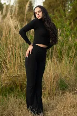 Conjunto de top de cuello alto y pantalón acampanado, ambos de color negro y con textura arrugada.