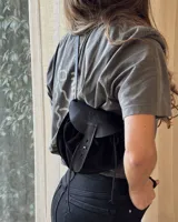 Bandolera marrón de cuero gamuzado con solapa de cuero liso y cierre con tira de cuero con botón a presión.