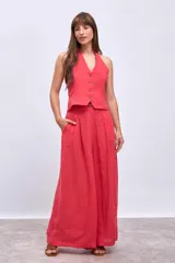 Chaleco color coral con escote halter y cierre frontal con botones.