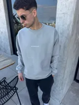 Buzo gris de algodón con corte oversize y bordado pequeño con la leyenda "BOHEMIANDESIGN" en el pecho.