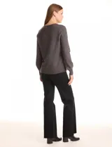 Buzo tejido color gris oscuro, con escote en V y manga larga. Presenta un aplique de tachas en la parte delantera.