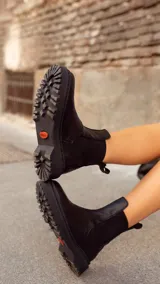 Bota Chelsea de cuero negro con elásticos laterales, suela track y tirador trasero. Diseño artesanal de producción local.