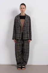 Pantalón cuadrillé de tiro bajo y silueta amplia, con cintura elástica, bolsillo trasero y calce levemente más ajustado en los tobillos.