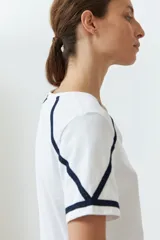 Remera blanca de algodón con escote en V y detalle de vainillas en mangas y hombros.