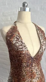 Vestido corto con estampado animal print en tonos marrones y blancos, con escote halter pronunciado y espalda descubierta.