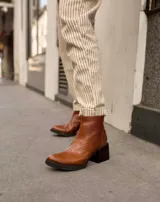 Botines negros de cuero con estampado de cocodrilo, taco cuadrado y cierre lateral con cremallera.