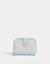 Billetera pequeña de cuerina color celeste con estampado de flores y cachemir en tonos pastel. Tiene cierre perimetral con cremallera y solapa con broche a presión.