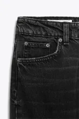 Pantalón de jean celeste, de tiro alto, corte mom fit, con cinco bolsillos y cierre frontal con cremallera y botón metálico.