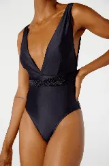 Traje de baño enterizo negro con escote en V profundo y cinturón trenzado a la altura de la cintura.