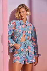 Chaqueta de denim celeste con estampado floral tropical y apliques bordados en pedrería.