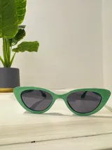 Lentes de sol verdes con forma de ojo de gato y cristales negros.