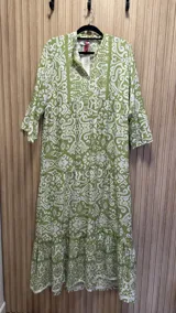 Vestido largo verde con estampado blanco, de corte amplio, cuello mao y mangas 3/4 con volados. Confeccionado en algodón.
