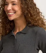 Blusa gris de punto acanalado con cuello polo, manga corta, botones en el cuello y bolsillo en el pecho.