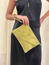 Sobre/cartera de gamuza color marrón oscuro, con diseño de solapa diagonal. Incluye una correa larga para usar al hombro o como bandolera, y una correa corta para la muñeca, ambas desmontables.