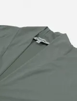 Blusa de manga caída color negro, con escote en V y cuello volcado, de fit regular.