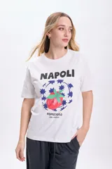 Remera blanca de manga corta con estampa de un tomate rodeado de estrellas azules y la inscripción "Napoli Pomodoro Bon Appetit".