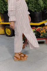 Sandalias de cuero color marrón y blanco, con suela track negra y ajuste con velcro.