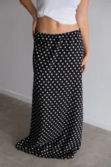 Pollera larga de fibrana color bordó con estampado de lunares blancos.