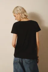 Remera negra de algodón y modal con estampa de un girasol y la frase "Peace of Mind".