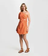 Vestido corto color naranja con textura geométrica, escote asimétrico con un hombro descubierto, manga corta abullonada y recorte en la cintura con lazo ajustable.