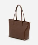 Bolso shopper grande color marrón de material sintético con doble asa, una fija y otra larga desmontable. Tiene cierre de cremallera y detalles de recortes.
