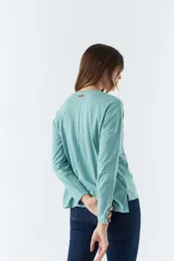 Remera blanca de algodón con mangas largas, cuello redondo y estampado frontal con la palabra 'Faith' en letras de diferentes colores.