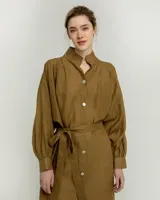 Vestido camisero negro de ramio con cuello mao, mangas largas abullonadas, cierre frontal con botones blancos y lazo a la cintura.