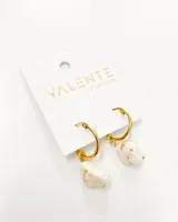 Aros de acero dorado con colgante de forma irregular en color blanco.