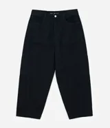 Pantalón negro de sarga, corte skater, con bolsillos grandes y recortes deslocados.