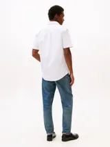 Camisa de hombre de manga corta, color blanco, confeccionada en puro algodón Oxford. Presenta cuello con botones y el logo de Tommy Hilfiger bordado en el pecho.