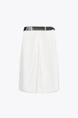 Falda midi color blanco hueso, de tiro alto y corte evasé. Incluye cinturón negro con hebilla metálica.