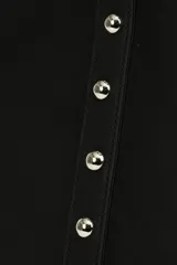 Bolso shopper negro con tachas plateadas en los laterales y en las asas. Tiene un bolsillo interno.