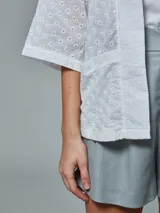 Kimono color blanco con bordado calado, mangas 3/4 y bolsillos laterales.