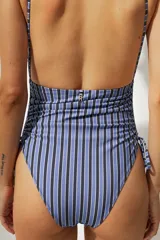 Malla enteriza con estampado a rayas verticales azules y negras, breteles finos y laterales con cordones ajustables.