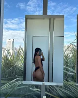 Body negro con escote halter profundo y espalda descubierta. Presenta tiras cruzadas en el frente y corte cavado.