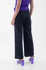 Pantalón negro de corte palazzo con lazo en la cintura.