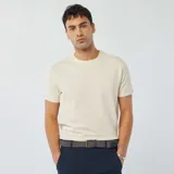 Camiseta color blanco hueso de tejido seersucker con cuello redondo y mangas cortas.