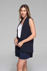 Chaleco azul marino con finas rayas verticales blancas, sin mangas, con solapas y bolsillos frontales.
