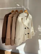 Chaqueta marrón con forro tipo corderito, doble botonadura y cuello con solapas.