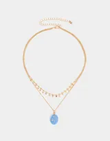 Collar corto dorado multicadena con dije ovalado celeste con estrellas y dijes de estrellas colgantes.