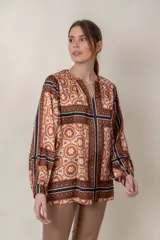 Blusa de seda estampada con diseño geométrico en tonos beige y tostado, de manga larga abullonada.