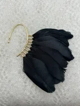 Ear cuff dorado con plumas negras.