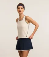 Musculosa deportiva ajustada de microfibra color crema con cuello halter, espalda nadadora y ribetes negros en cuello y sisas.