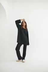 Conjunto verde oliva de punto morley, compuesto por un buzo de corte holgado con mangas largas y aberturas laterales, y un pantalón palazzo de tiro alto.