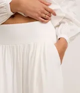 Pollera evasé midi color blanco, confeccionada en viscolino con 30% de lino, con lastex en la parte trasera de la cintura y forro interno.